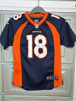 Front view of navy and orange Denver Broncos jersey number 18