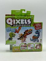 Front of sealed Qixels Dino package displaying cube count and age rating
