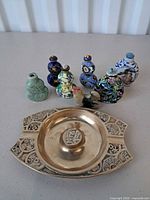 Group shot of seven snuff bottles, rooster figurine and brass dish