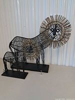 Both wire lion sculptures with AA battery for scale