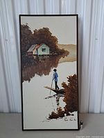 Front view of framed oil painting depicting boatman, cottage, water, artist signature visible