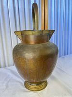 Front view showing copper body, brass foot and handle