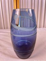 Full view of the blue glass vase showing applied swirl bands