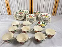 Full set laid out with cups in foreground, plates behind