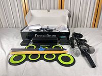 Full lot view: drum pad, control module, pedal, drumsticks, microphones, cables, box