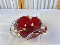 Side view showing red core encased in clear glass with sculpted rim