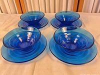 Complete set of four bowls each on matching saucer plates