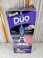 Front of retail box showing Shark Sonic Duo cleaner and compatibility with carpets and hard floors