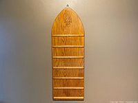 Full view of arched oak hymn board hanging on wall