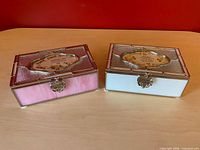 Pair of glass keepsake boxes side by side showing color difference