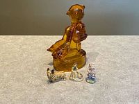 Amber glass Girl with Geese figurine and three Wade England ceramic miniatures