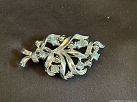 Front view of brooch showing rhinestones and scroll design