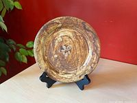 Front of stoneware plate showing glaze pattern and central motif