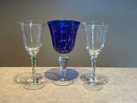 Front view of three wine glasses showing bowl shapes and stem colors