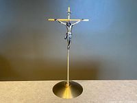 Full view of freestanding brass crucifix with silver-tone corpus and INRI plaque