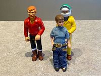 Front view of three vintage articulated figures standing on surface