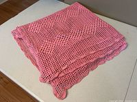 Tablecloth folded showing crochet pattern and scalloped border