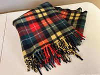 Blanket folded to show overall plaid pattern and fringe