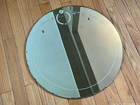 Full view of round mirror front showing etched floral motif and border