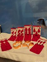 All seven packaged Celebrate It silicone molds and three copper-tone cookie cutters displayed on cloth