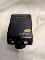 Top view showing Canon Speedlite 300EZ label, zoom range markings, JCII sticker, hot shoe mount