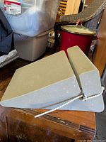 Side view showing angled gray foam wedge with attached rope-held neck roll