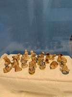 Full group of seventeen Wade miniature figurines on cloth backdrop