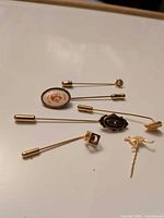 All six stick pins laid out showing variety of heads and clutches