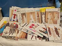 Overview of entire group of pattern envelopes stacked on table.