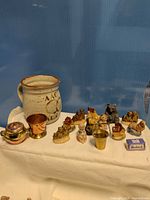 Group shot of mug, ceramic minis, brass and copper pieces