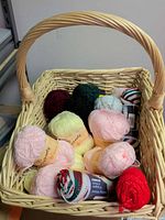 Wicker basket filled with assorted yarn skeins