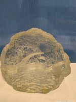 Front view of clear resin sculpture showing birds and water texture