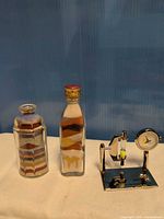 Overall lot showing both sand art bottles and Ocean Park desk clock/timer
