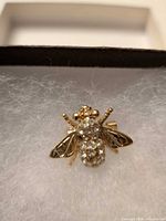 Front view of bee brooch showing rhinestone body and gold tone wings