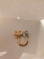 front view showing gold and silver masks with connecting loop