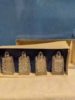 Set of four glass shakers in box