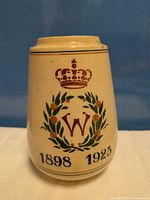 Front view showing crown, W monogram, laurel wreath and dates 1898 1923