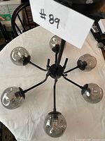 Top view of 6-arm black metal light fixture with glass globes