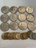 Obverse view of Eisenhower dollars and smaller golden dollars