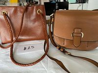 Front view of both brown leather handbags