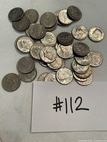 Pile of assorted Kennedy half dollars with #112 card visible