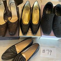 Four pairs of women’s flats on boxes and table