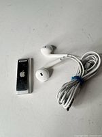 Apple iPod Shuffle with wired EarPods coiled beside