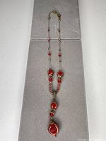 Full view of necklace laid flat showing length, bead arrangement and pendant