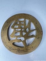 Full view of round brass trivet front side