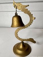 Full view of brass dragon stand with hanging bell