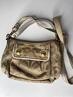Front view of Coach beige jacquard bag with both straps visible