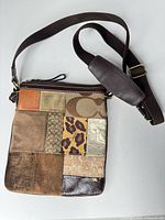 Front view of Coach patchwork crossbody bag showing strap and patchwork design