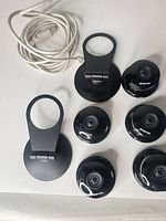 Six Dropcam camera fronts, two stands, white USB cable
