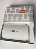 Closed sterilizer in original box showing Facebook logo and packaging marked "UV Sterilizer"